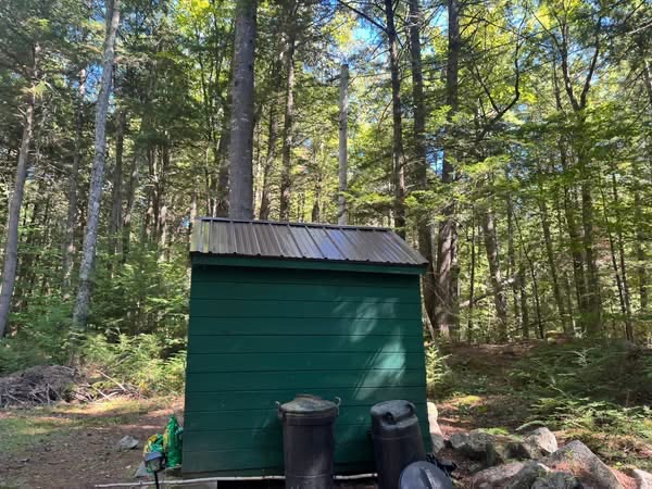 Green storage shed with new metal roof