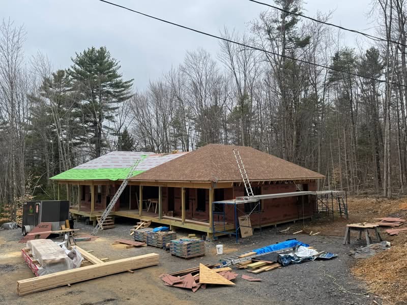 New shingle roof installation in progress on a custom Maine home