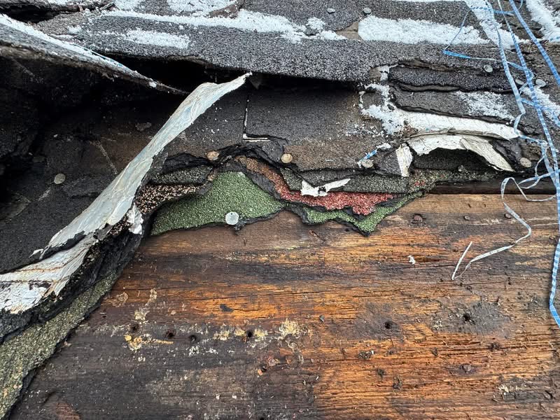 Close-up of failing roof layers before replacement