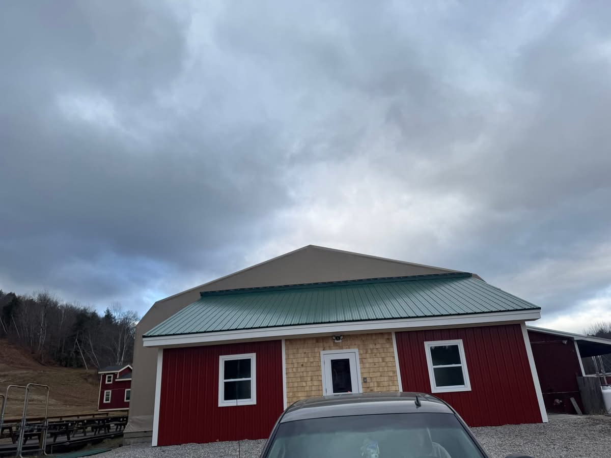 Barn with green standing seam metal roof and red siding