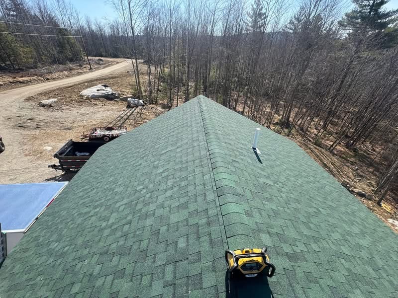 Aerial view of completed green shingle roof