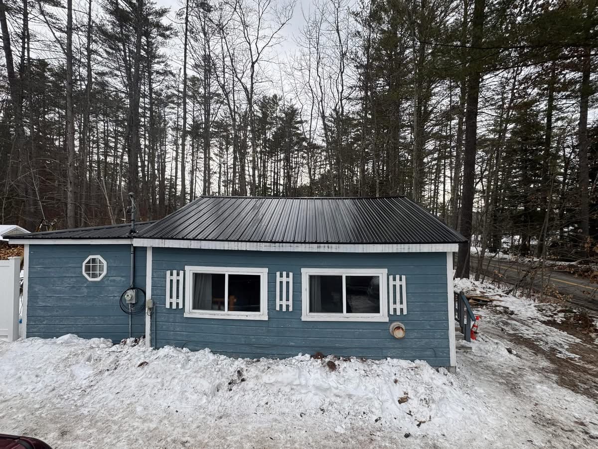 Blue cottage with new black metal roof