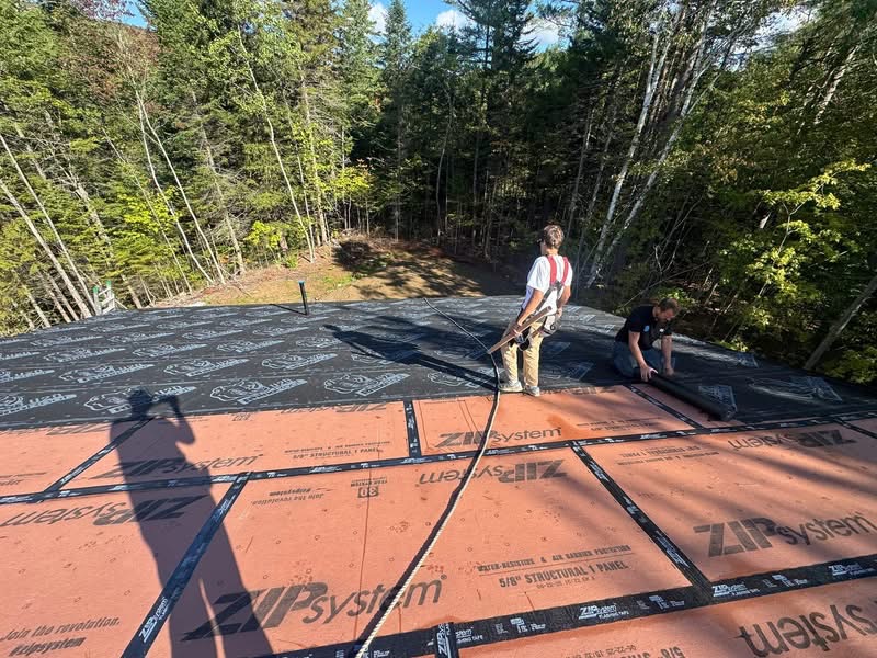 Crew installing new roof underlayment on a Maine home