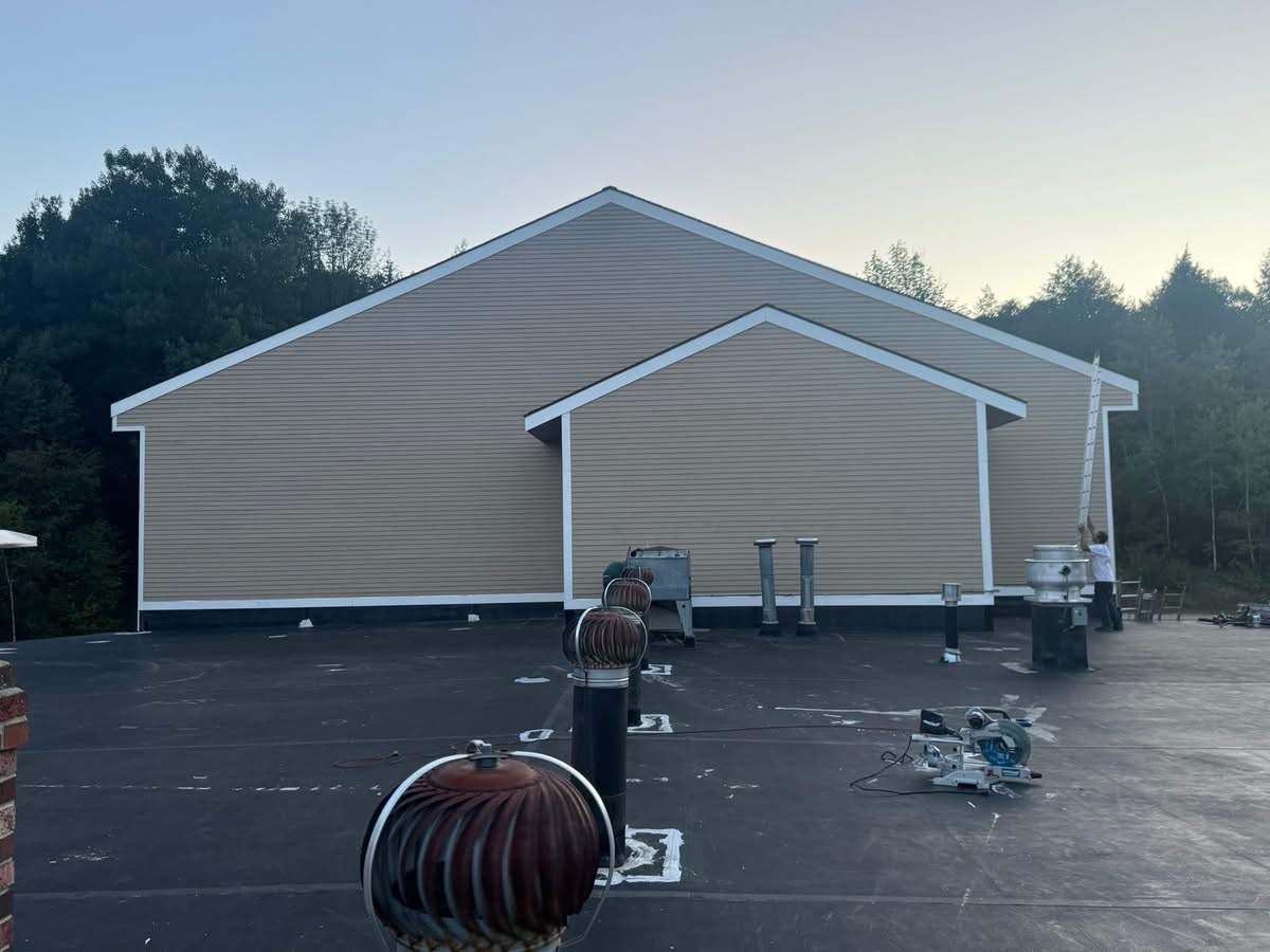 Large commercial building with new tan siding and white trim
